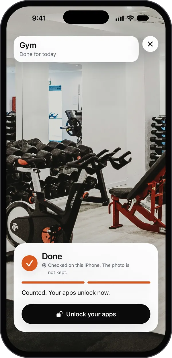 Toll's camera in a gym: a photo of dumbbell racks, a spin bike and a weight bench, marked Done and checked on this iPhone, the photo not kept. Counted. Your apps unlock now. A black button: Unlock your apps.